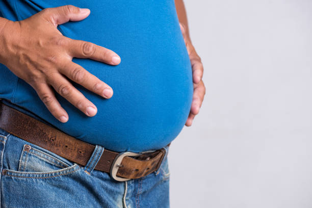 homme-adulte-de-poids-excessif-ou-gros-dans-des-jeans-très-serrés-sur-un-fond-gris-soins-de